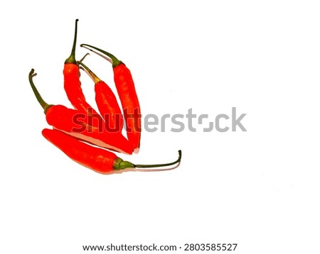 This image shows 5 red cayenne peppers (Capsicum frutescens), one of the hottest types of chili in Indonesia, on a white background.