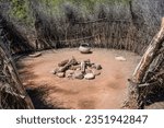 This image shows an ancient Native American campsite with a fire pit inside of a hut.