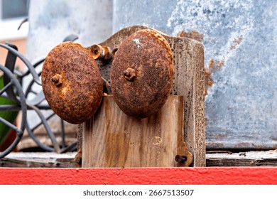 This image shows a close-up of a rusty metal object with two circular elements that appear to be part of a larger structure or machinery