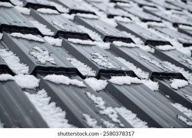 This image shows a closeup of a snowcovered roof, highlighting the textures of the roofing material beneath the frost and emphasizing the harsh, cold weather that creates this scene