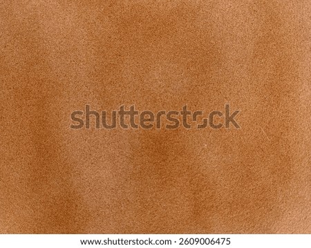 This image shows a close-up texture of light brown suede material. The surface appears soft, slightly fuzzy, and evenly shaded with natural gradients, typical of suede or microfiber fabrics.