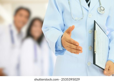 This image shows a doctor extending a hand for a handshake, symbolizing a welcoming gesture or introduction. The doctor is holding a clipboard with medical forms. - Powered by Shutterstock