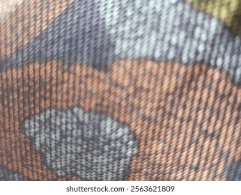 This image shows a fabric pattern with abstract motifs in dark and light gray. The surface is dotted with small spots, creating a complex texture and interesting contrast.