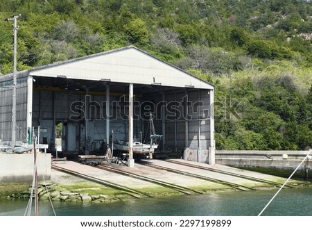 This image shows a fishing boat dock inside a fishing port.
This port is on the coast of the inland sea of Japan.
This kind of scene is commonly seen in the rural areas of Japan.