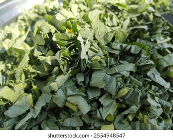 This image shows freshly chopped green leafy vegetables. The texture and appearance suggest they might be from a type of leafy green like spinach or mustard greens. Concept Healthy Eating - Powered by Shutterstock