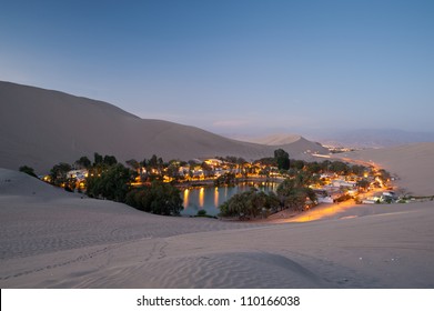 This image shows the oasis town of Huacachina, Peru at night