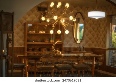 This image shows a a stylish mid century modern dining room with a long table, brass centerpiece, hutch, and warm sunset lighting through an arch way.  - Powered by Shutterstock