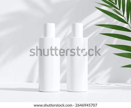 This image shows two sleek, white cosmetic bottles standing side by side on a clean surface, with natural light and shadows from palm leaves creating a 
minimalistic and fresh aesthetic.