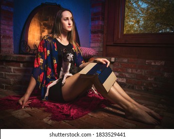 This Image Shows A Woman Taking A Break While Reading Book By A Rustic Fire Place While Holding Her Italian Greyhound Dog.