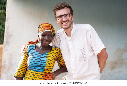 In This Image, A Young White Volunteer Doctor Is Happily Smiling Into The Camera With A Recovered African Woman Wearing Atraditional Dress And Headscarf Ready To Leave The Village