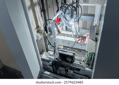 This is an interior view of an elevator shaft with essential mechanical parts and wiring