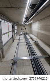 This is an interior view of an elevator shaft with the mechanical parts and wiring essential for the renovation of a freight elevator. Regular repair, servicing, and maintenance of the elevator.