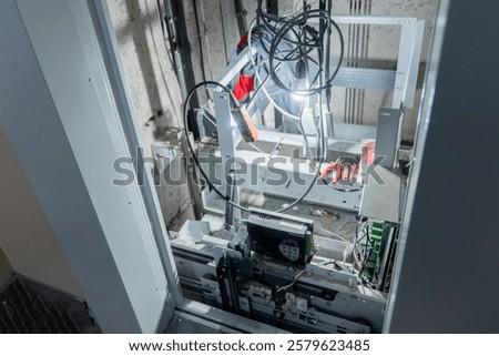 This is an interior view of an elevator shaft with essential mechanical parts and wiring