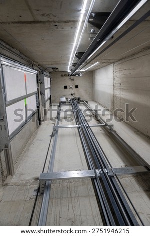 This is an interior view of an elevator shaft with the mechanical parts and wiring essential for the renovation of a freight elevator. Regular repair, servicing, and maintenance of the elevator.