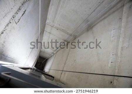 This is an interior view of an elevator shaft with the mechanical parts and wiring essential for the renovation of a freight elevator. Regular repair, servicing, and maintenance of the elevator.
