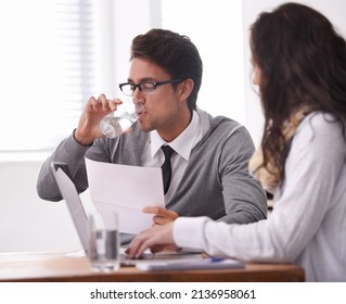 This Interview Is Giving Me A Dry Mouth. A Young Man Drinking Water During An Interview.