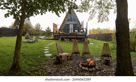 This inviting scene features a modern cabin with a warm fire pit, creating a serene ambiance for a peaceful retreat