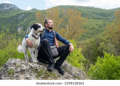 If this isnt loyalty, I dont know what is. Cropped shot of a handsome mature man sitting on a rock with his golden retriever after a day out hiking.