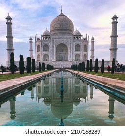 This is the jewel of the Muslim Art with a green and blue symmetrical water fountain in front. This white marble mausoleum Taj Mahal in Agra, India was built in memory of the Emperor's wife.
