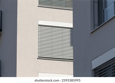 This is a large structure, characterized by numerous windows that are equipped with blinds for privacy and light control