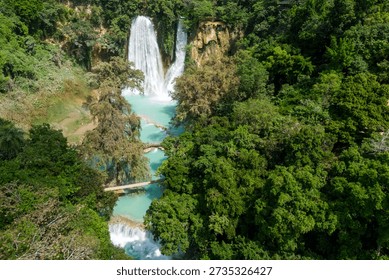 This location features multiple waterfalls flowing into a turquoise pool. Visitors can explore the natural beauty and dense tropical vegetation in Huasteca Potosina, San Luis Potosi, Mexico.