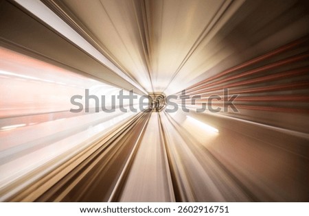 This long exposure shot captures a metro station tunnel, conveying a sense of rapid movement and depth. The lines and lights blur together, creating an abstract yet dynamic atmosphere.