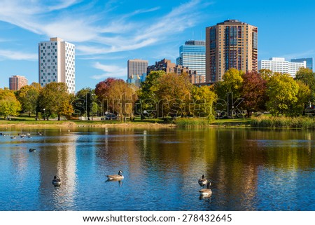 This is Loring Park in Minneapolis, Minnesota. This shows part of the skyline. This was taken during autumn. These are Canadian Geese on the lake. 