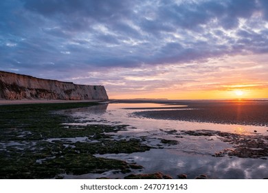 This lovely coastal sunset display features stunning cliffs, tide pools, and a sky painted with vivid colors - Powered by Shutterstock