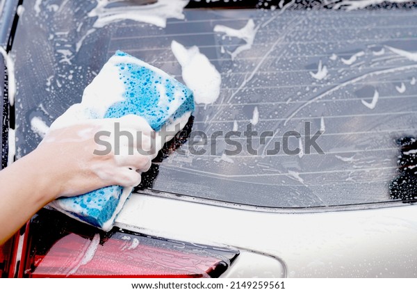 This man is\
washing the car and cleaning the\
car.