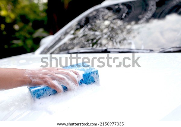 This man is\
washing the car and cleaning the\
car.