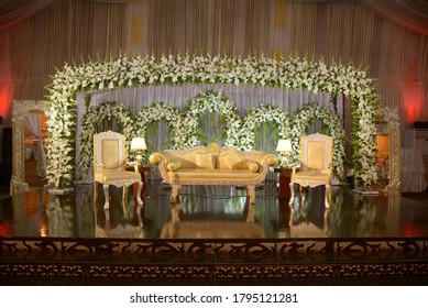 This Is A Marriage Ceremony Stage For Bride And Groom Decorated With Beautiful Fresh And Attractive White Flowers, A Couch And Two Chairs. Captured In Lahore On March 3, 2019.