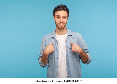 This is me! Portrait of self-confident narcissistic man in worker denim shirt smiling satisfied and pointing himself, feeling self-important, proud, famous. studio shot isolated on blue background