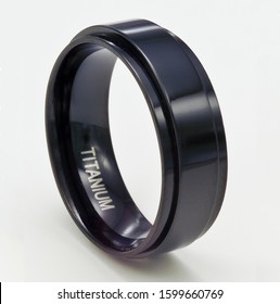 This men's spinner band ring of black oxided titanium is shown isolated on a white background.
