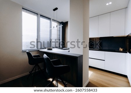 This modern kitchen features stylish bar seating that enhances the space and invites light