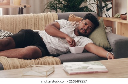 This is a much needed break. Shot of a young man lying on his couch at home.