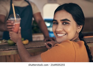 This is my favourite food truck. Shot of a woman buying and drinking a smoothie from a food truck. - Powered by Shutterstock