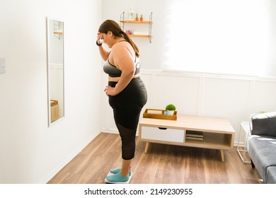 This Is Not Healthy. Worried And Sad Fat Woman Using The Scale And Weighing Herself 