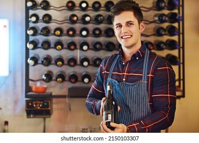 This One Will Hit The Spot And Your Pocket. Shot Of A Handsome Young Man Choosing A Bottle Of Wine In A Restaurant.