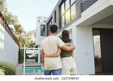 This Is Ours Now. Rearview Shot Of A Young Couple Standing Outside Their New Home.