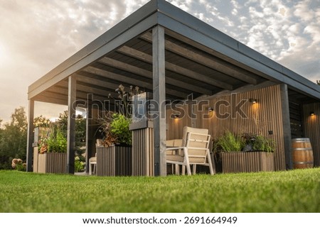 This outdoor space features comfortable seating, plants, and warm lighting, perfect for relaxation in the evening glow.