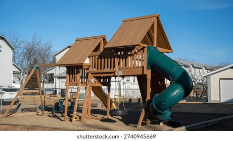 This outdoor swing set is the Backyard Discovery Skyfort II, made from cedar wood. It includes a treehouse, a green spiral slide, swings, and a flat slide.