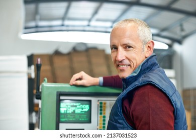 This Panel Is The Nerve Center Of The Factory. Portrait Of A Mature Man Standing Next To Machinery In A Factory.