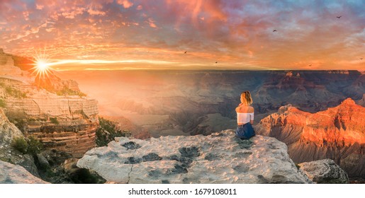 This is a panoramic photograph of a young woman sitting on the edge of rim and enjoying the Grand Canyon sunset
