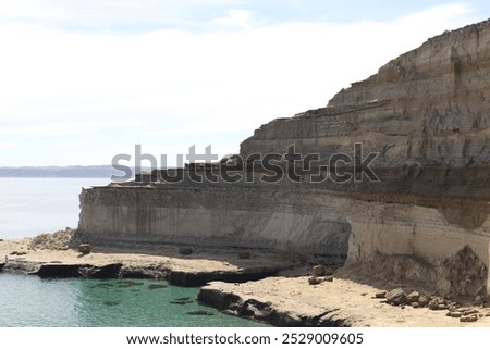 This panoramic view captures the stunning cliffs of Puerto Madryn National Park in Argentina, showcasing the rugged coastline and the vast expanse of the ocea