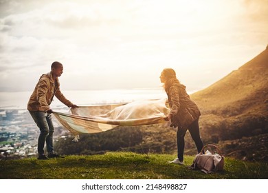 This Is The Perfect Spot For A Picnic. Shot Of Two Young Friends Setting Up A Picnic Outside.