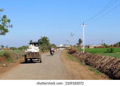 This Photo Captured In Indian Small Village And Rural Areas In Gujarat India. Horizontal Road, Farm Land, Small Tractor, Also Motorcyclist And Lane Of Electricity Pole Beautiful Village Landscape