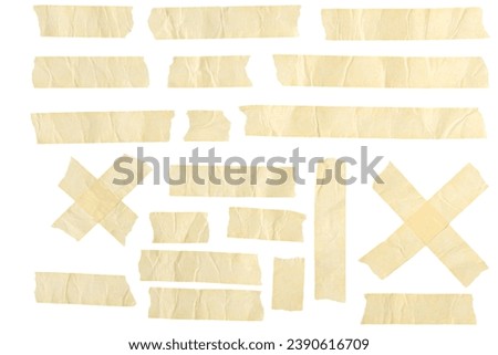 This photo features an array of masking tape and adhesive strips arranged on a plain white background. Various lengths of beige colored duct tape are shown.
