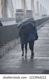 This Photo Have Been Taken At India Longest Cable Bridge In Bharuch District Of Gujarat In India. A Lovely Couple Walking In A Having Rain Making Environment More Romantic For Them.