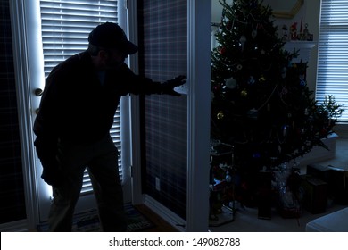 This Photo Illustrates A Burglary Or Thief Breaking Into A Home At Night Through A Back Door During The Christmas Holiday Season. View From Inside The Residence.