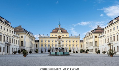 
This photo showcases the grand symmetrical courtyard and Baroque architecture of Ludwigsburg Palace in Germany, featuring a central fountain. Ideal for travel, architecture, and historical content.  - Powered by Shutterstock